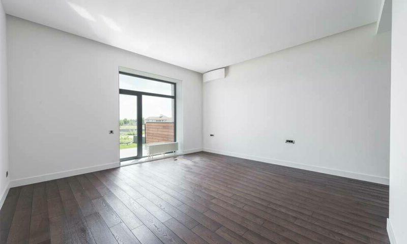 光秃秃的房间，白色的墙壁和深色的硬木地板